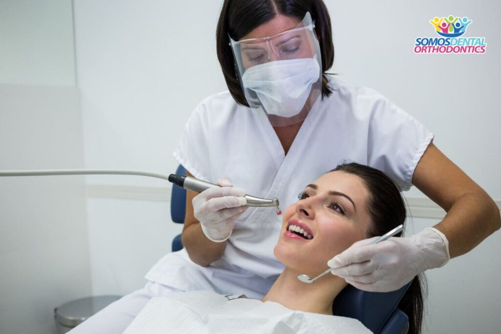 dentista examinando a paciente femenina para prevenir el dolor de oido después de una extracción de muela del juicio