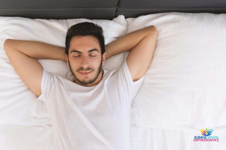 man placing his hands behind his head sleeping peacefully wondering how to sleep after wisdom teeth removal