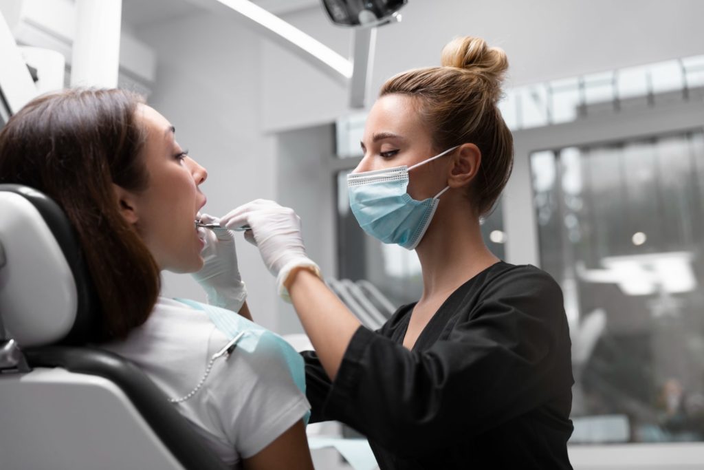 medium shot dentist wearing mask explaining the signs you need braces