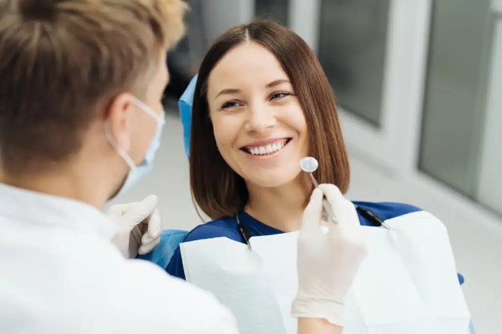 male professional dentist with gloves mask discuss what treatment will look like patient teeth explaining the fastest way to straighten teeth