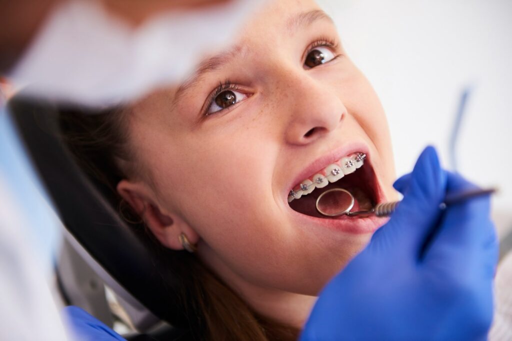 girl with braces during routine dental examination discovering how to speed up braces process
