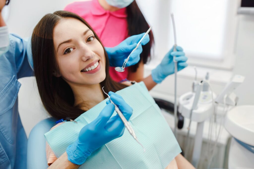 smiling woman in dentist chair learning how long do braces take to fix overbite