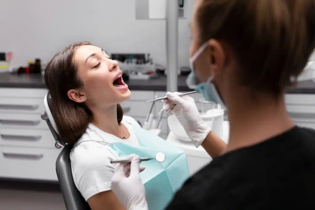 Orthodontist with female patient explaining is braces or Invisalign cheaper