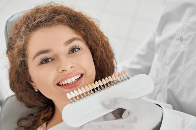 woman smiling while male dentist keeping teeth color range and discovering how long do dental crowns last