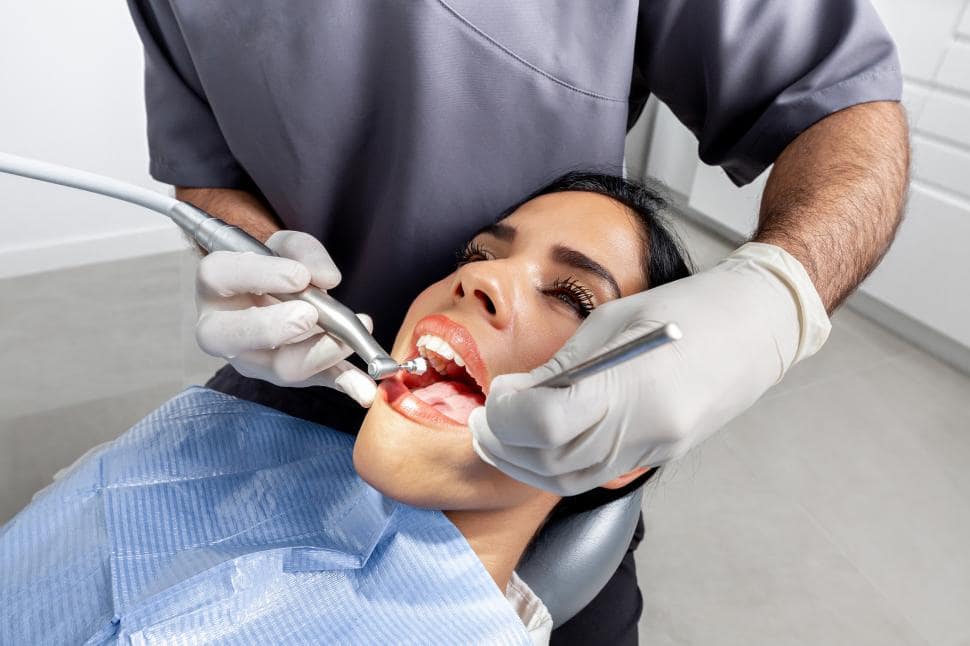 Latin woman in a dentist clinic receiving a dental cleaning discovering if can you get your braces off whenever you want