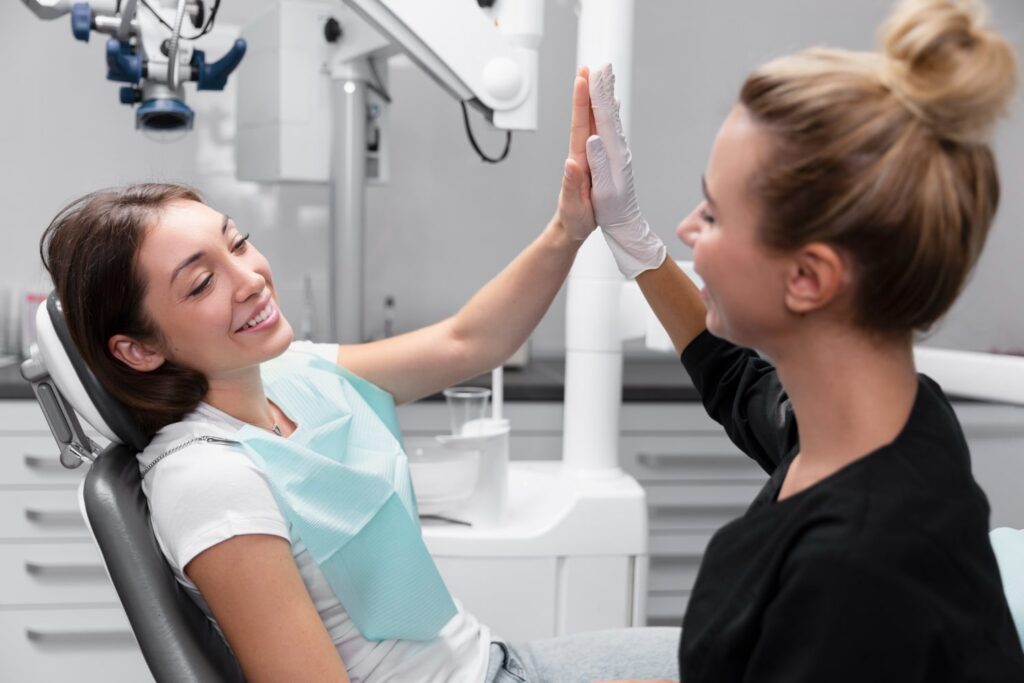 medium shot smiley women high five with their dentist who explains how to get braces off faster