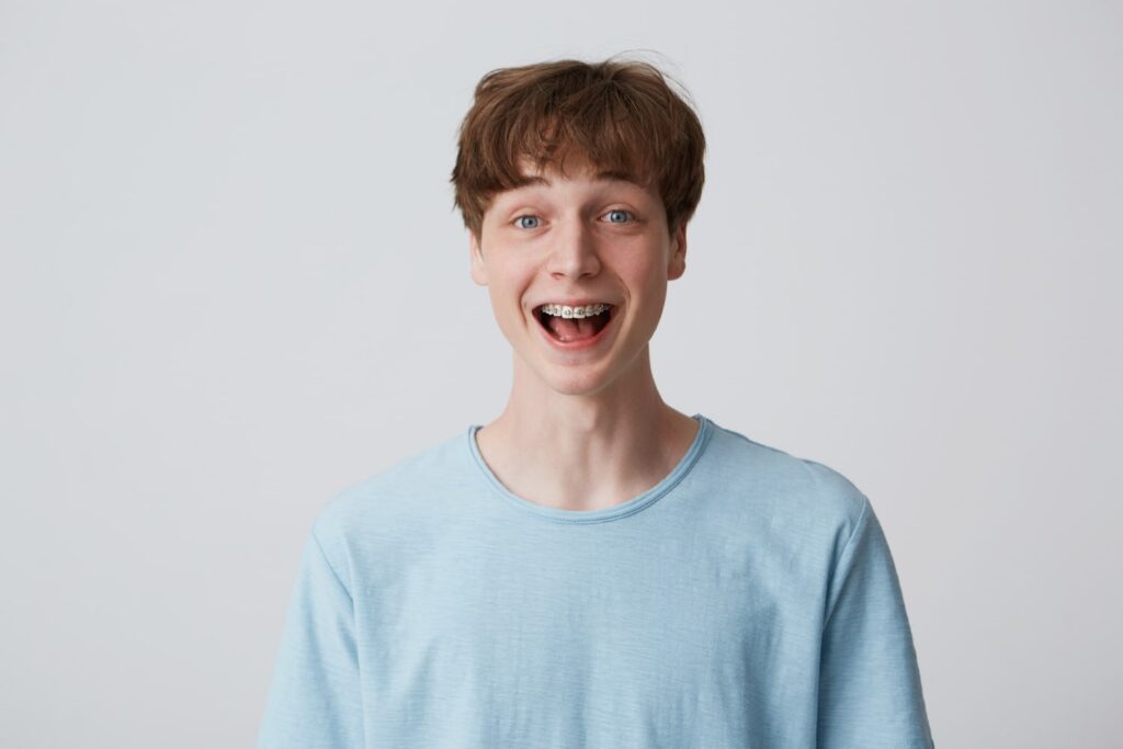 close up amazed excited young man for found cheap braces in dallas with short disheveled hair
