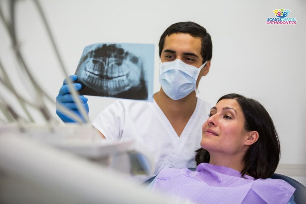 young-male-dentist-examining-x-ray-with-female-patient-to-explain-why-remove-wisdom-teeth