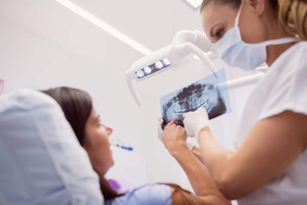 Dentist showing X-rays to the patient, explaining if you can eat after getting a dental crown