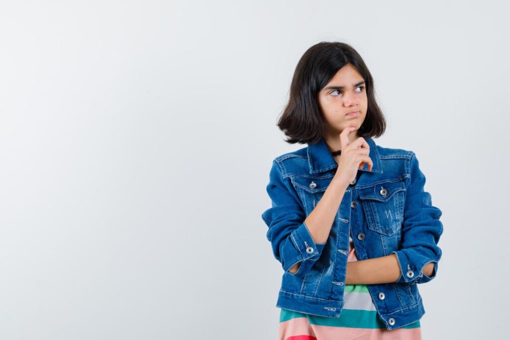 teenager girl with denim coat put hand chin thinking what to do before getting braces in front of isolated white background