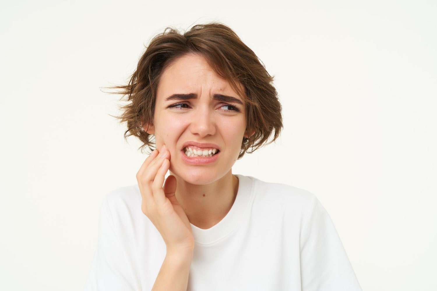 Close up of a woman with wisdom teeth pain thinking if will my teeth straighten after wisdom teeth extraction