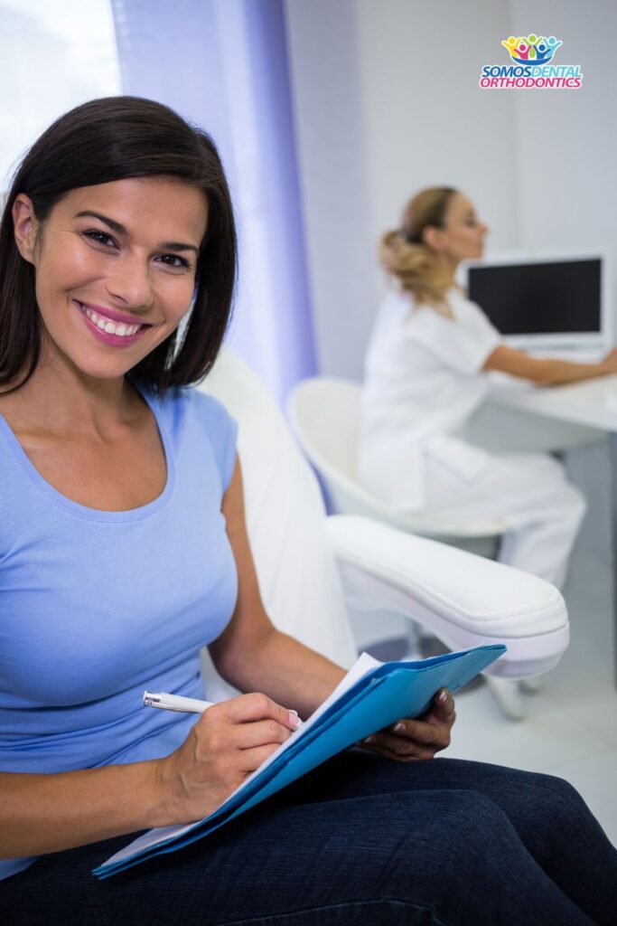 Smiling female patient writing a medical record to receive an affordable root canal treatment in phoenix arizona