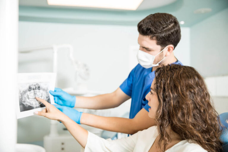 mid adult dentist showing xray teeth to a female patient to explain the benefits of floss for braces