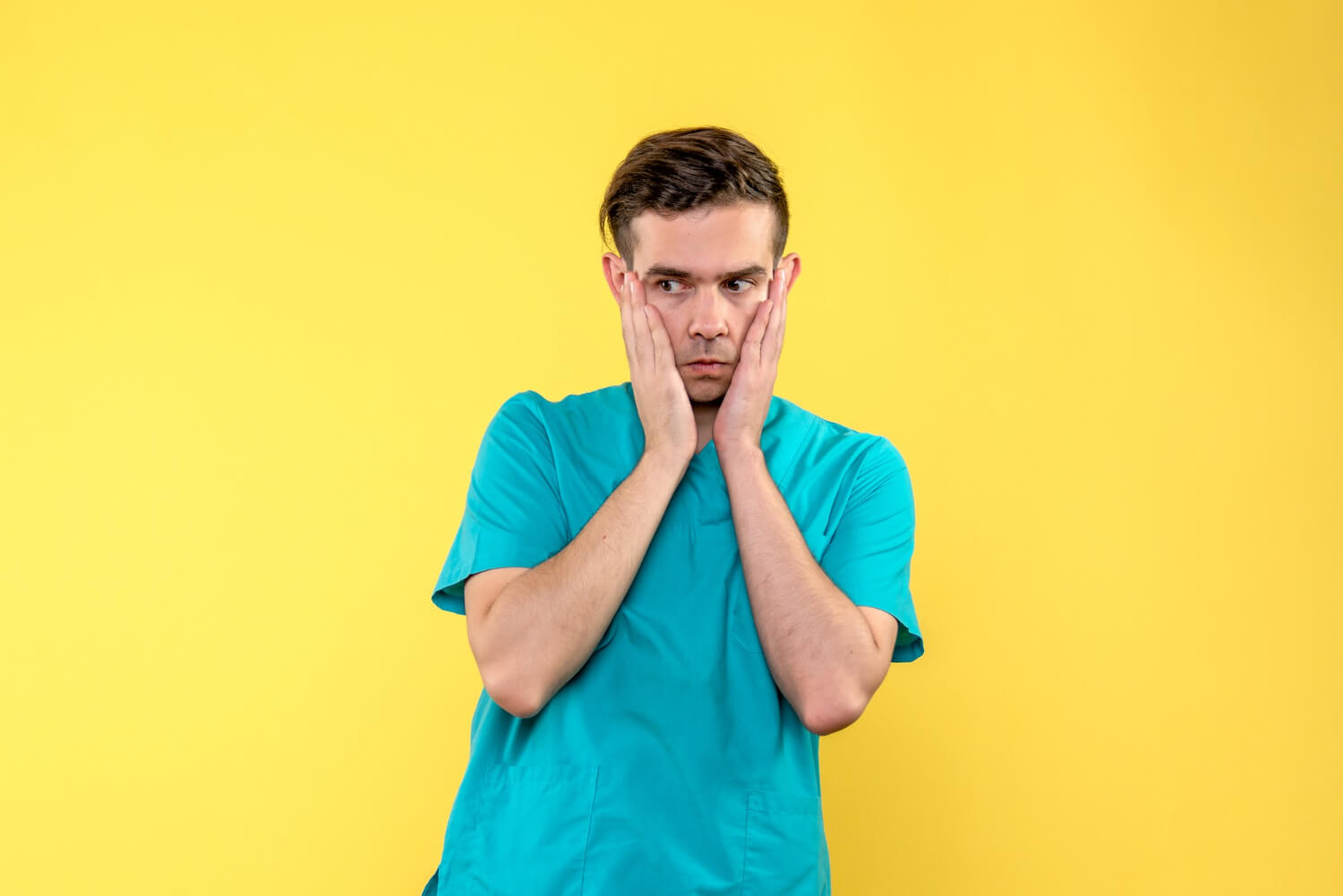 Front view of male doctor worried if do they brake your jaw to remove wisdom teeth on yellow wall