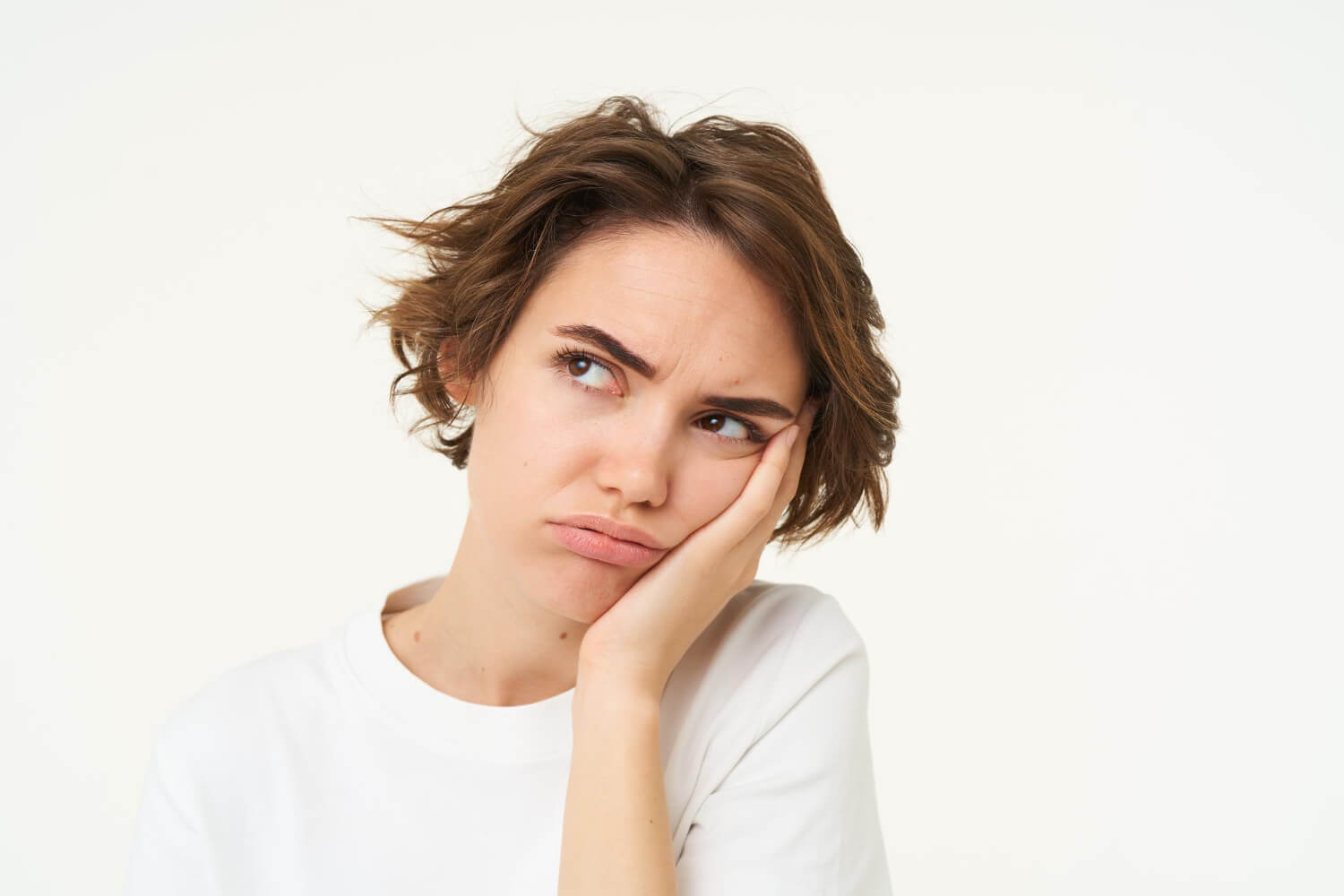 Portrait of young woman hand and frowns looks upset thinking why do my teeth feel loose with braces