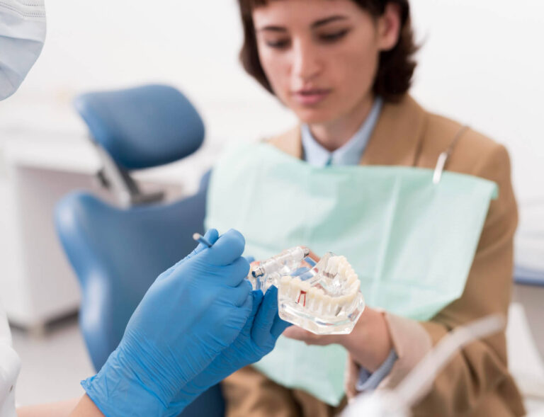 Female patient looking at dental mold with orthodontist learning if can a chipped crown be repaired