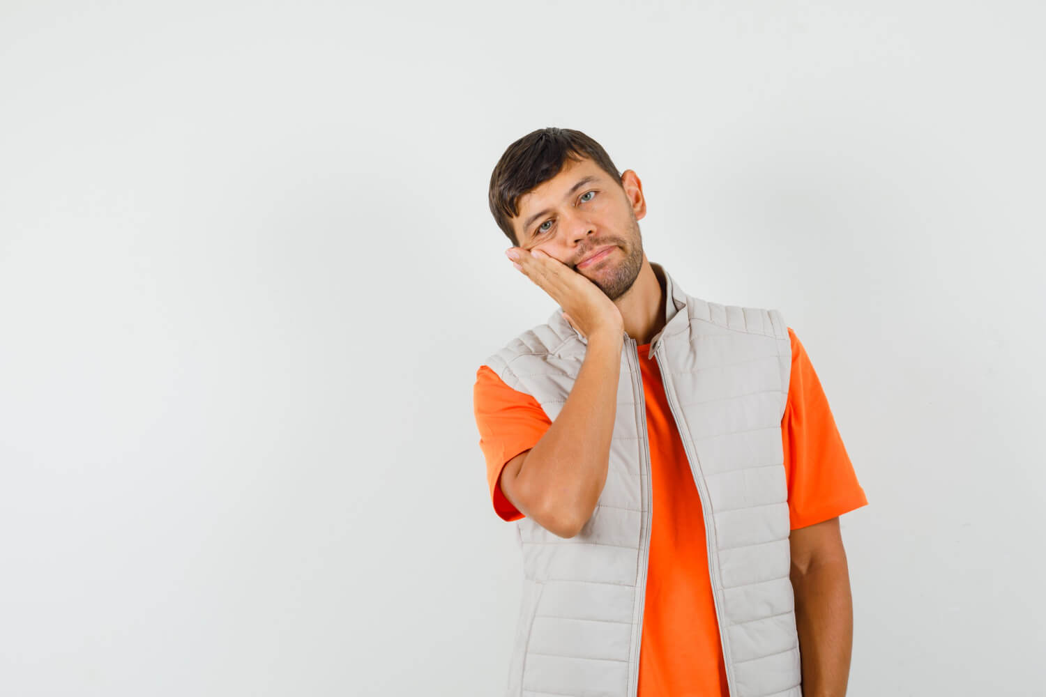 Young man in t-shirt, jacket leaning cheek on raised palm and thinking if do wisdom teeth grow back