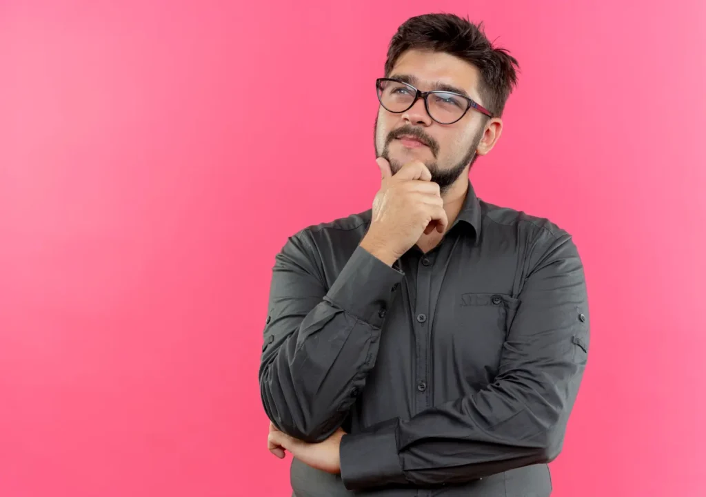 Looking-at-up-thinking-young-hispanic-man-wearing-glasses