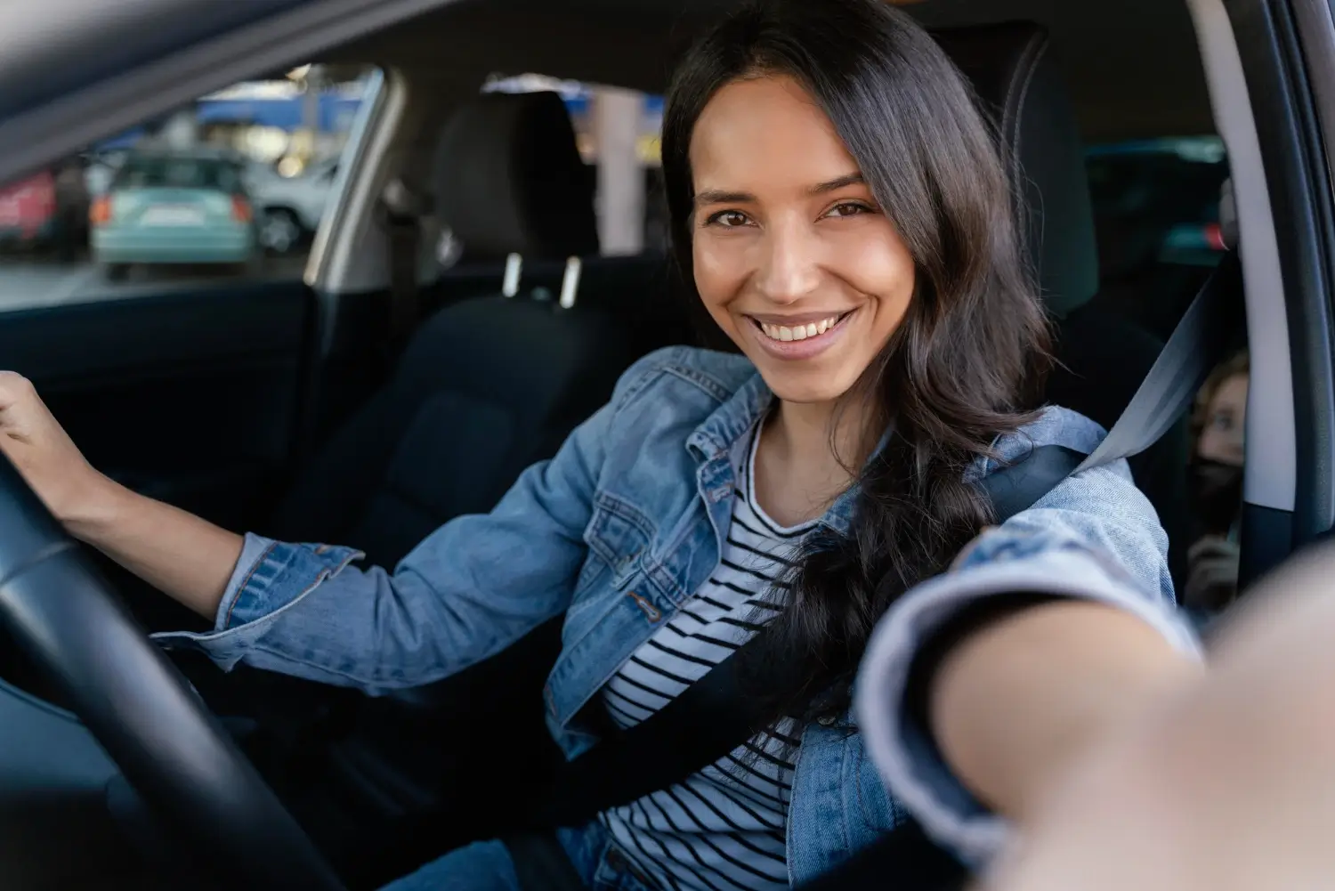 Mujer morena tomando un selfie en su coche