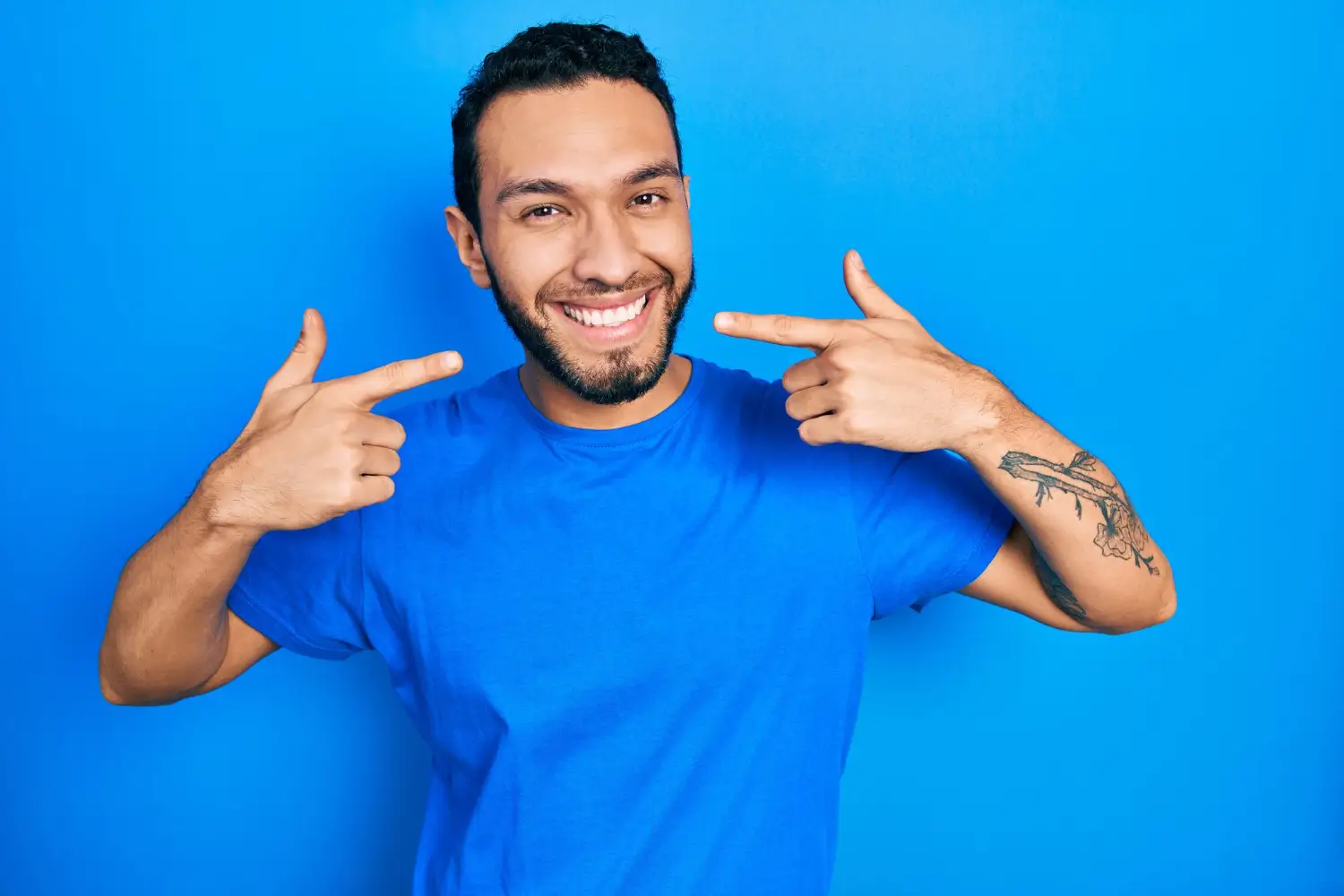 hombre-hispano-con-barba-con-camiseta-azul-casual-sonriendo